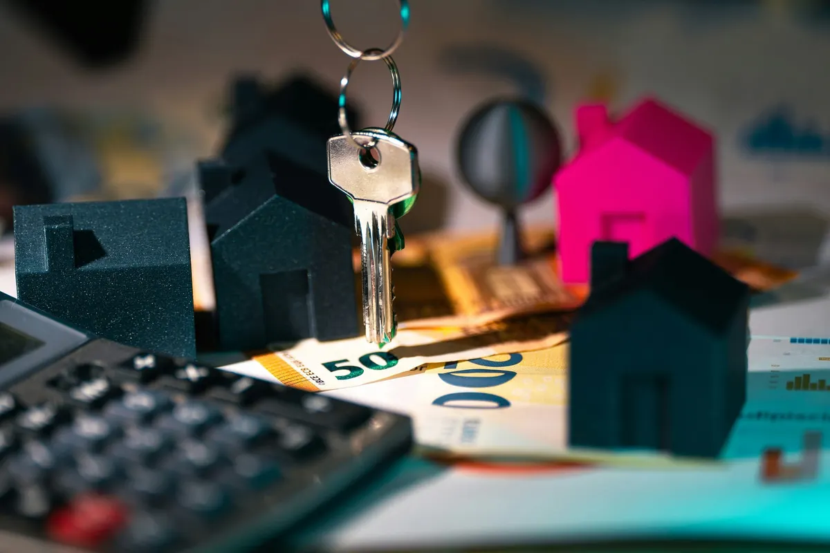 Llave y casitas sobre papeles de una tasación